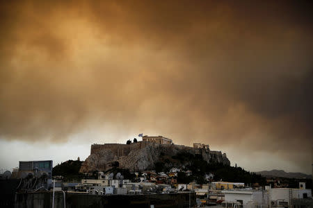 Smoke from a wildfire burning outside Athens is seen over the Parthenon temple atop the Acropolis hill in Athens, Greece, July 23, 2018. REUTERS/Alkis Konstantinidis