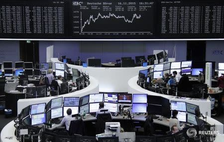 Traders work at their screens in front of the German share price index DAX board at the stock exchange in Frankfurt, Germany November 16, 2015. REUTERS/Remote/Staff -