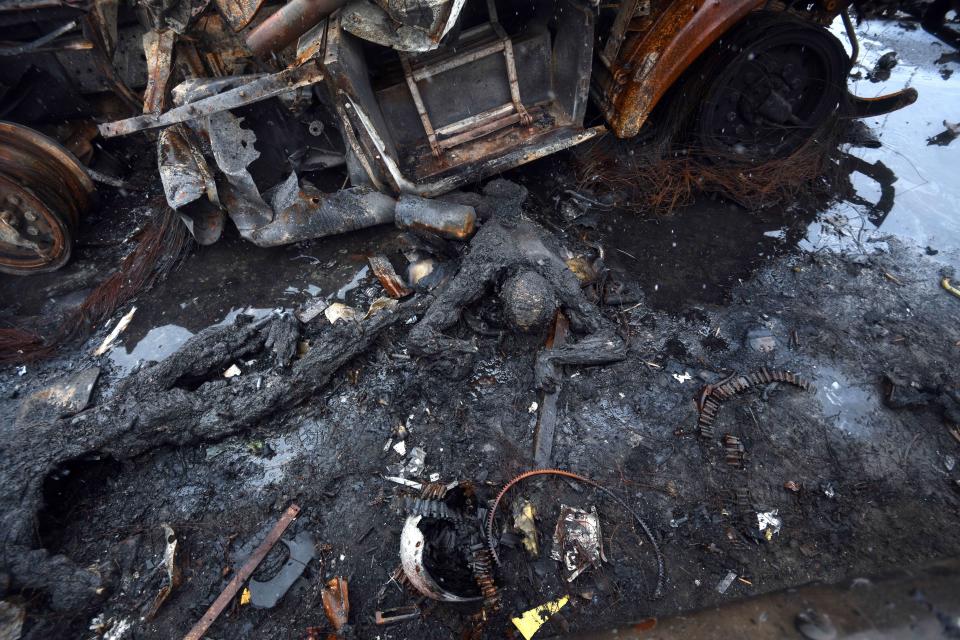 A wrecked vehicle and dead body on a street in Bucha, Ukraine.