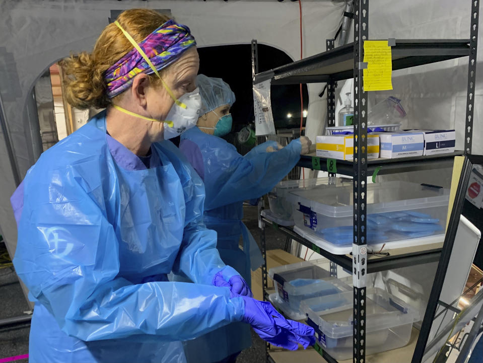 Nurse Chris Rutledge suits up in personal protective equipment before entering the patient wards of a COVID-19 field hospital, Friday, Jan. 15, 2021, in Lenoir, N.C. Rutledge works for Samaritan’s Purse, the international Christian relief organization which built the temporary facility to take pressure off local hospitals overwhelmed with coronavirus cases. (AP Photo/Sarah Blake Morgan)