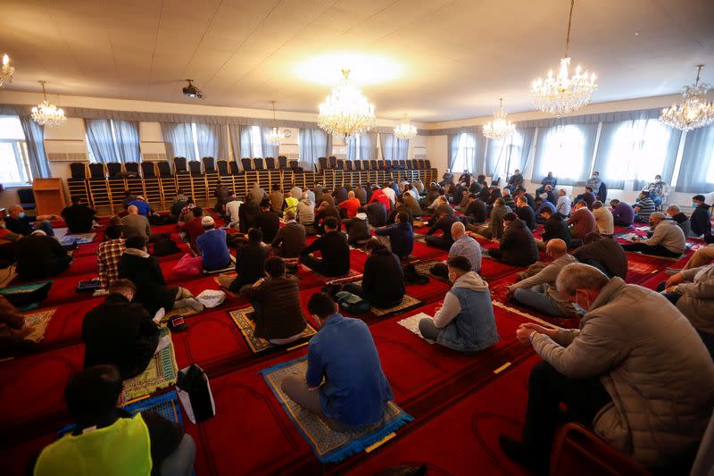 Muslims pray for victims of a gun attack during their Friday prayer in a mosque in Vienna