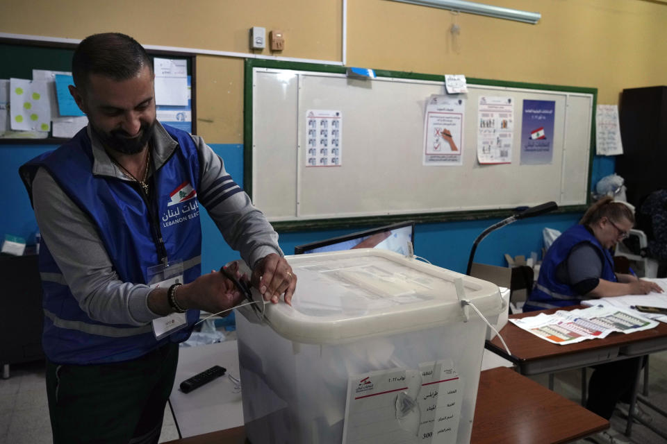 An election official opens a ballot box shortly after polling stations closed, in the northern city of Tripoli, Lebanon, Sunday, May 15, 2022. Lebanese voted for a new parliament Sunday against the backdrop of an economic meltdown that is transforming the country and low expectations that the election would significantly alter the political landscape. (AP Photo/Bilal Hussein)