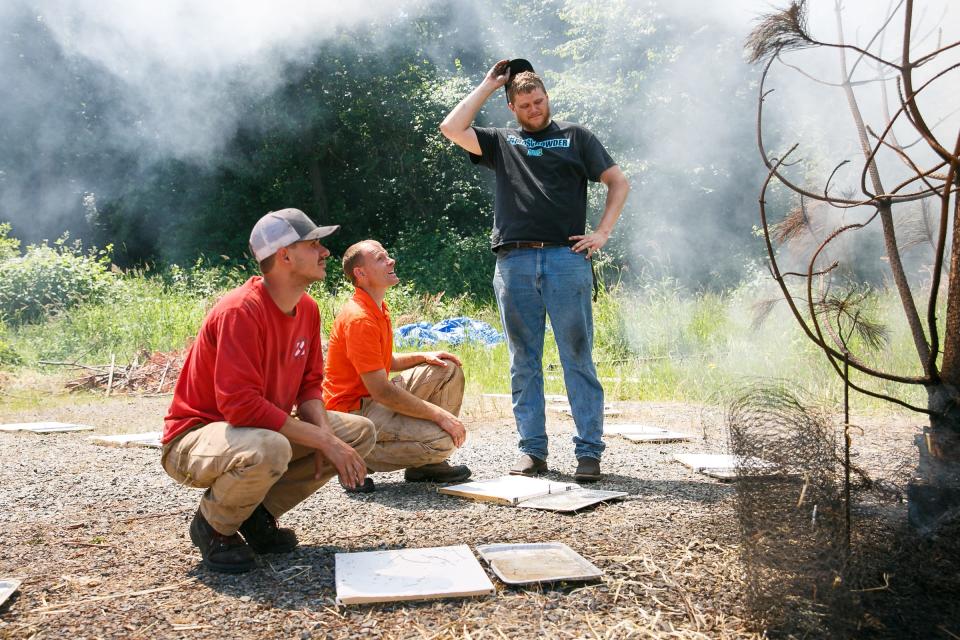 Then-master's student Tyler Hudson, associate professor David Blunck and then-undergraduate Ryan Bray look at fire-resistant fabric in 2018 to see how many embers resulted from setting fire to a small stand of ponderosa pine.