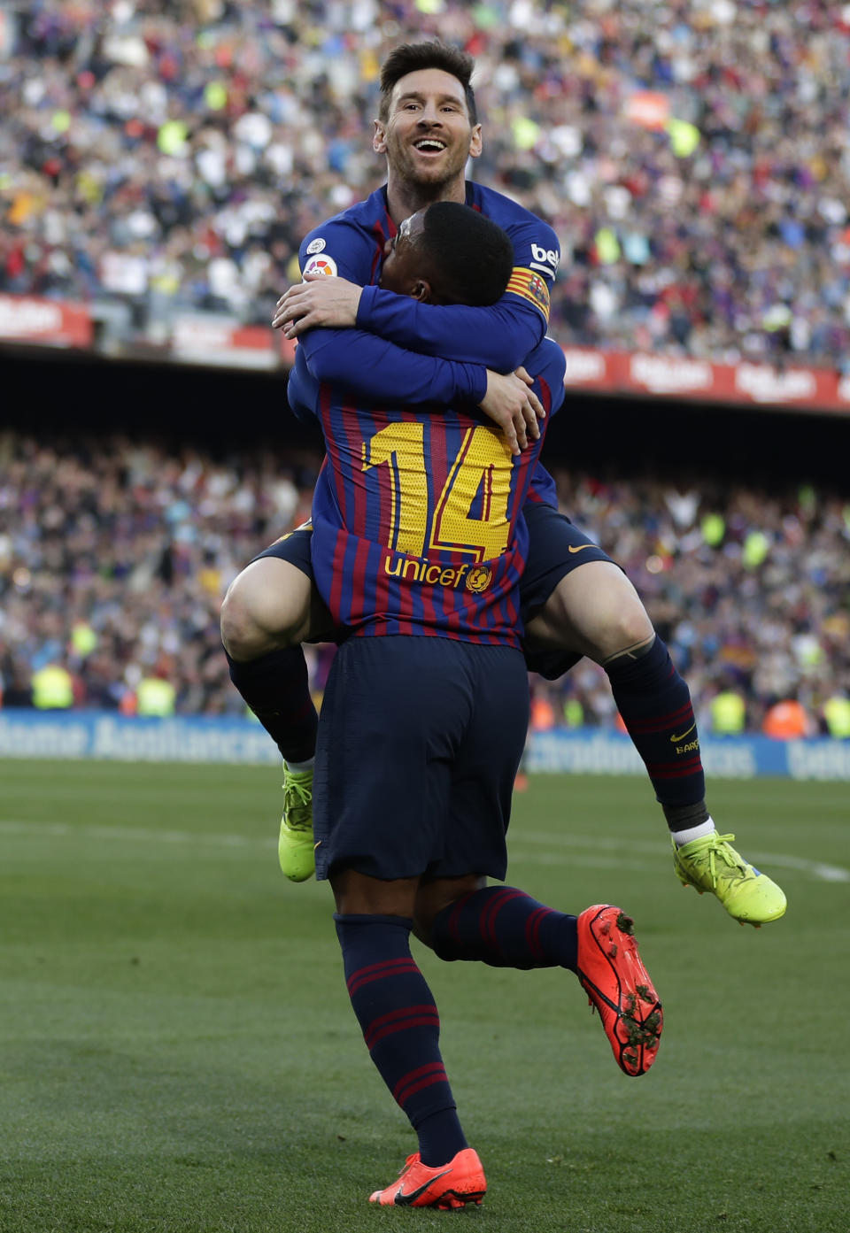 Barcelona's Lionel Messi, top, celebrates with Malcom after scoring his side's second goal during a Spanish La Liga soccer match between FC Barcelona and Espanyol at the Camp Nou stadium in Barcelona, Spain, Saturday March 30, 2019. (AP Photo/Manu Fernandez)