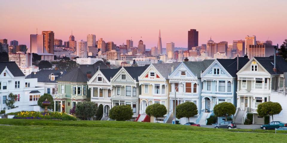 Victorian houses known as the Painted Ladies of the Alamo Square Historic District contrast with the modern skyline of the Financial District, San Francisco, California.