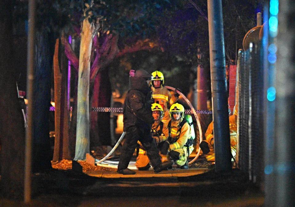 Ein Bombenentschärfer in Schutzkleidung passiert Sicherheitskräfte vor einer Polizeiwache in Merrylands, einem Vorort von Sydney. (Bild: Sam Mooy/via Reuters)