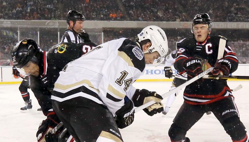 Chicago Blackhawks center Jonathan Toews is hit in the face by a high stick from Pittsburgh Penguins left wing Chris Kunitz (14), next to Michal Rozsival (32) during the first period of an NHL Stadium Series hockey game at Soldier Field on Saturday, March 1, 2014, in Chicago. (AP Photo/Charles Rex Arbogast)