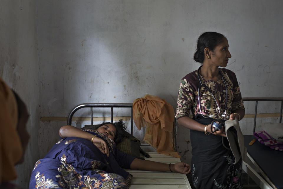 SITTWE, BURMA - MAY 06: Amina Kerto, 27, lays in a clinic in the Dar Paing refugee camp. A Rohingya medic checks on her fever and infected leg but is unable to do anything for her with such limited access to medecine and equipment on May 6, 2014 in Sittwe, Burma. Some 150,000 Rohingya IDP (internally displaced people) are currently imprisoned in refugee camps outside of Sittwe in Rakhine State in Western Myanmar. Medecins Sans Frontieres (MSF), the primary supplier of medical care within the camps, was banned in March by the Myanmar government. Follow up attacks by Buddhist mobs on the homes of aid workers in Sittwe put an end to NGO operations in the camps. Though some NGOs are beginning to resume work, MSF remains banned, and little to no healthcare is being provided to most Rohingya IDPs. One Rohingya doctor is servicing 150,000 refugees with limited medication. Several Rakhine volunteer doctors sporadically enter the camps for two hours a day. Births are the most complicated procedures successfully carried out in the camps, requests to visit Yangon or Sittwe hospitals for life threatening situations require lengthy applications and are routinely denied. Malnutrition and diarrhea are the most widespread issues, but more serious diseases like tuberculosis are going untreated and could lead to the rise of drug resistant tuberculosis (DR-TB).  (Photo by Andre Malerba/Getty Images)