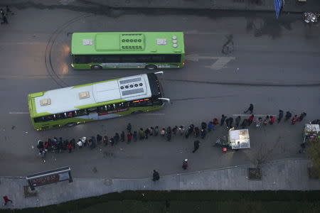 People wait for a bus to take them to Beijing from Yanjiao, Hebei province, China November 13, 2015. REUTERS/Jason Lee