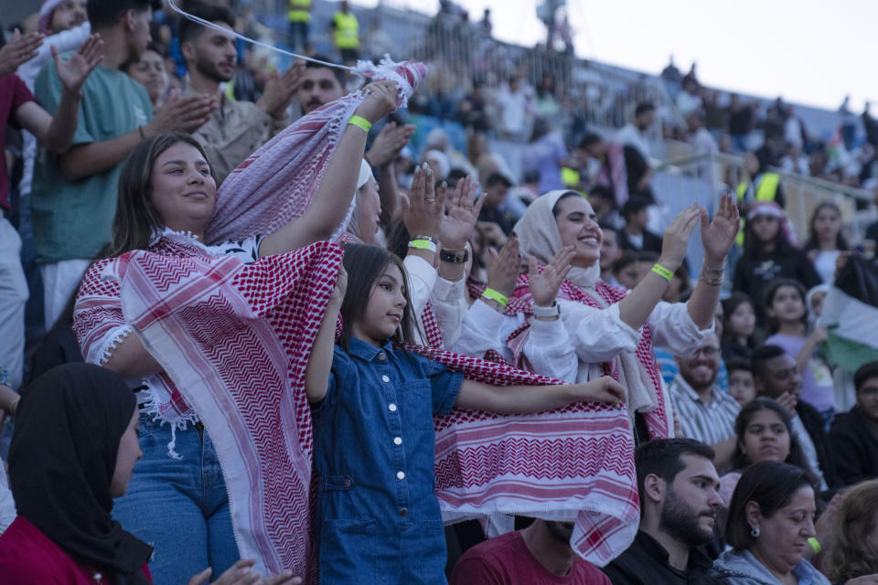 Jordanian women wearing the traditional Jordanian red and white checkered scarf and T-shirts dance and sing during a concert at a sports stadium in Amman, Jordan, Monday, May 29, 2023. The free concert featuring well-known Arab singers, including Egyptian star Tamer Hosny, was part the celebrations leading up to the wedding of Crown Prince Hussein and his fiancee, Saudi architect Rajwa Alseif later this week. (AP Photo/Nasser Nasser)