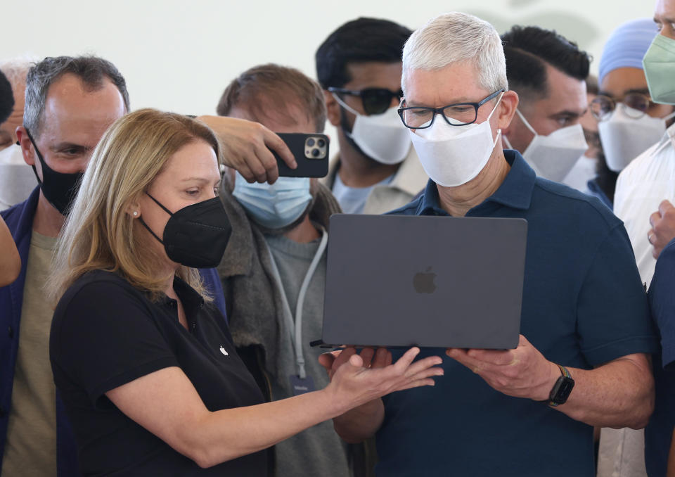 Le PDG d'Apple, Tim Cook, examine un ordinateur portable MacBook Air récemment repensé lors de la WWDC22 le 6 juin 2022 à Cupertino, en Californie.  (Photo de Justin Sullivan/Getty Images)