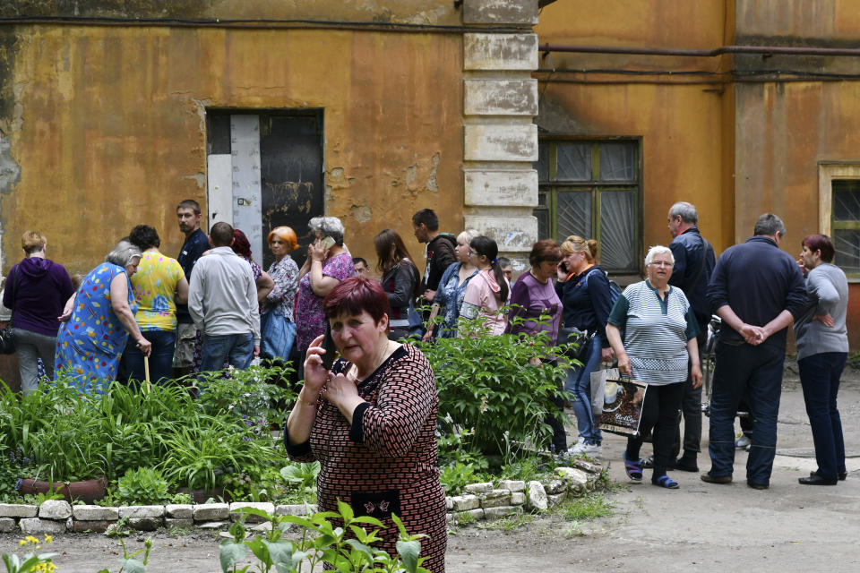 People wait to receive humanitarian aid in Kramatorsk, Ukraine, Saturday, May 28, 2022. (AP Photo/Andriy Andriyenko)