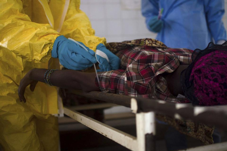 Medical staff take a blood sample from a suspected Ebola patient at the government hospital in Kenema, July 10, 2014. Ebola has killed 632 people across Guinea, Liberia and Sierra Leone since an outbreak began in February, putting strain on a string of weak health systems facing one of the world's deadliest diseases despite waves of international help. Picture taken July10, 2014. REUTERS/Tommy Trenchard (SIERRA LEONE - Tags: HEALTH)