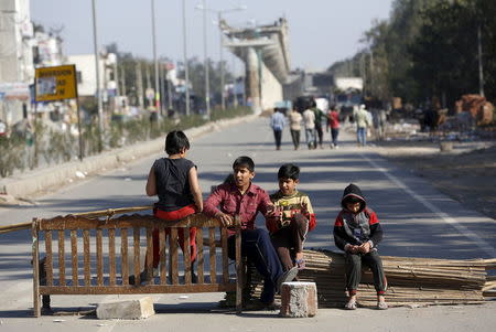 Children sit on a road blockade by the demonstrators from the Jat community to block the Delhi-Haryana national highway during a protest at Sankhol village in Haryana, India, February 21, 2016. REUTERS/Adnan Abidi