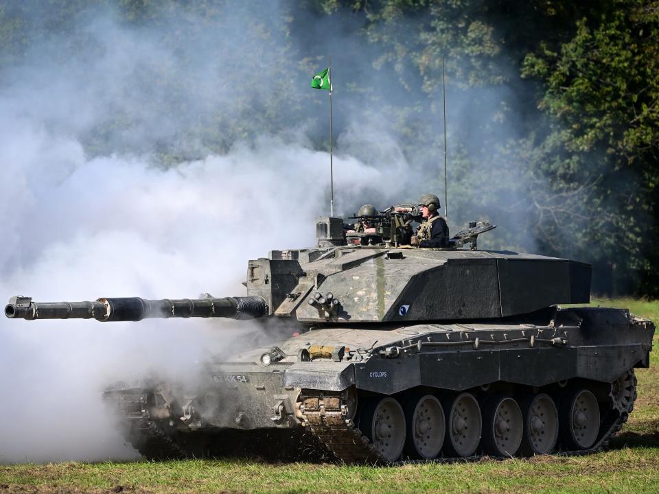 A Challenger 2 main battle tank uses smoke as camouflage during a demonstration for the families watching The Royal Tank Regiment Regimental Parade, on September 24, 2022 in Bulford, England.
