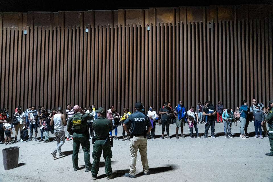 Migrants and asylum seekers are detained by U.S. Border Patrol agents after crossing the U.S.-Mexico border in Yuma County, Ariz., on July 28, 2022.