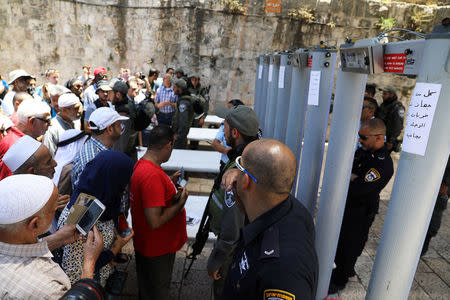 Palestinians stand in front of Israeli police officers and newly installed metal detectors at an entrance to the compound known to Muslims as Noble Sanctuary and to Jews as Temple Mount, in Jerusalem's Old City July 16, 2017. REUTERS/Ammar Awad