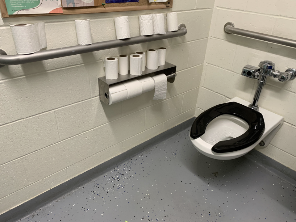 A bathroom with a bunch of toilet paper rolls