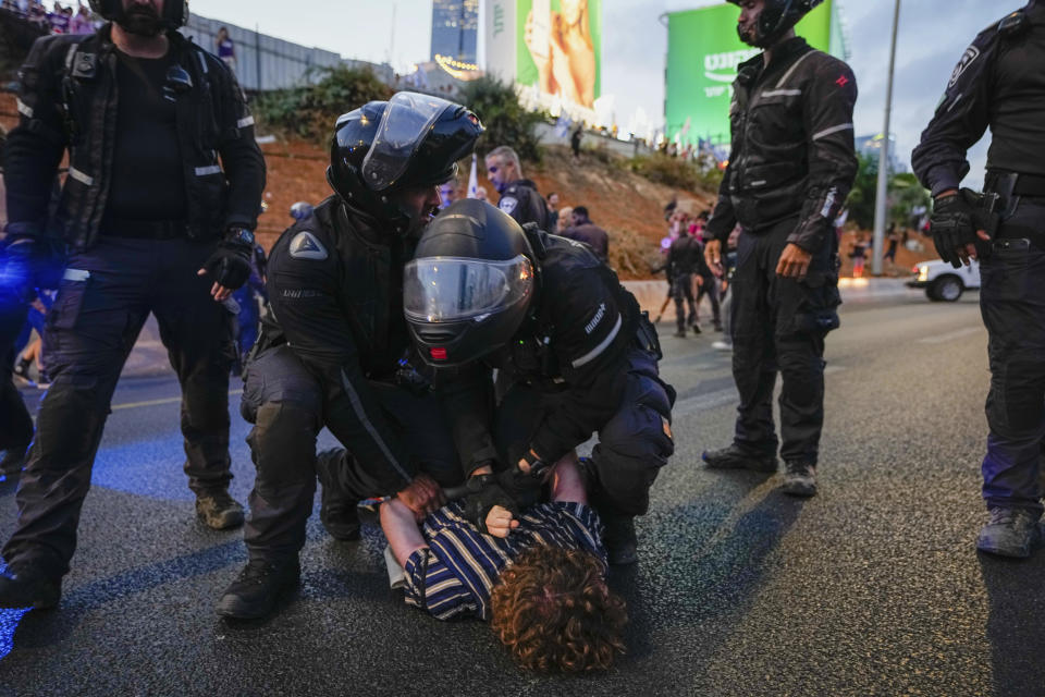 Israeli police officers disperse demonstrators blocking a highway during a protest against plans by Prime Minister Benjamin Netanyahu's government to overhaul the judicial system, in Tel Aviv, Israel, Saturday, July 1, 2023. (AP Photo/Ariel Schalit)