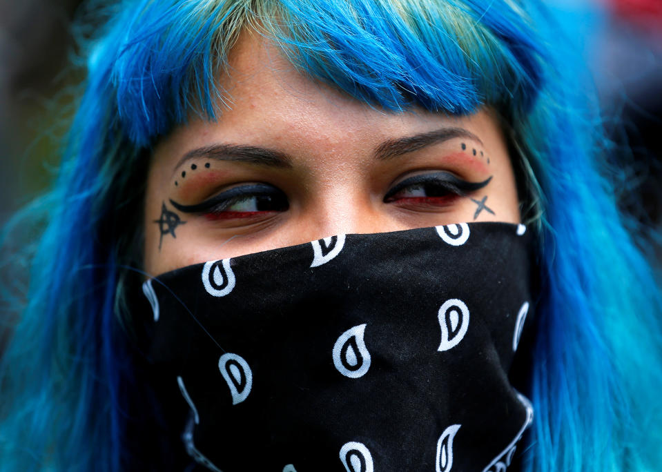 <p>A demonstrator conceals part of her face as she protests near the convention center where Republican presidential candidate Donald Trump held a campaign rally in Anaheim, Calif., on May 25, 2016. (Reuters/Mike Blake) </p>