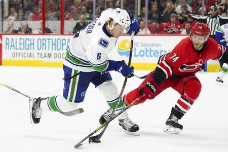Oct 9, 2018; Raleigh, NC, USA; Vancouver Canucks right wing Brock Boeser (6) shoots the puck as Carolina Hurricanes defenseman Jaccob Slavin (74) defends during the second period at PNC Arena. Mandatory Credit: James Guillory-USA TODAY Sports