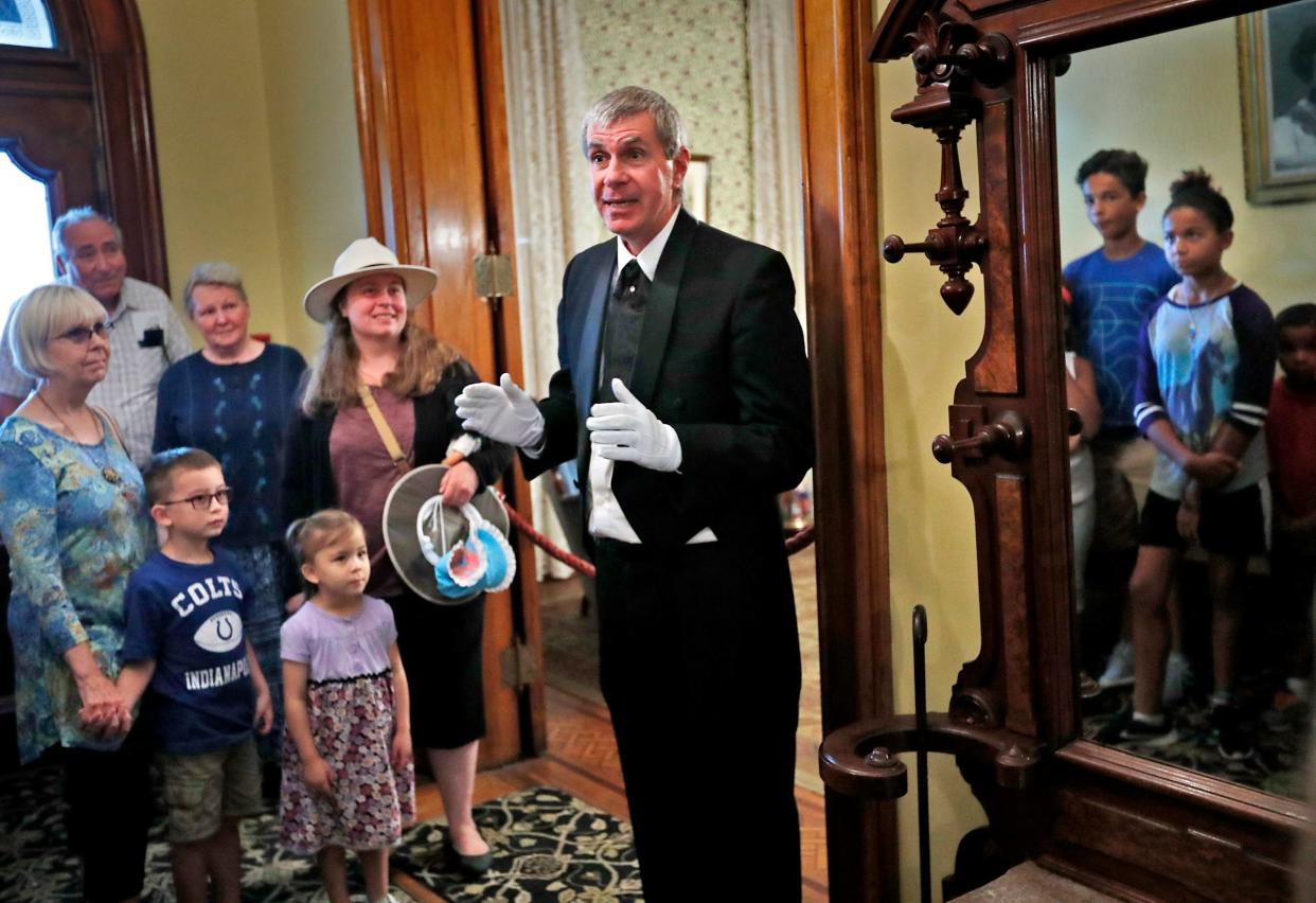 Mike Back, center, as Charles, the Benjamin Harrison home butler, welcomes visitors to the Benjamin Harrison Presidential Site, Monday, Aug. 20, 2018.