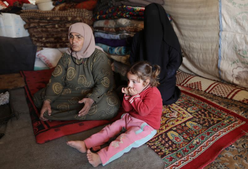 Aziza Hadaja, an internally displaced woman, sits with her relatives inside a tent near the town of Afrin