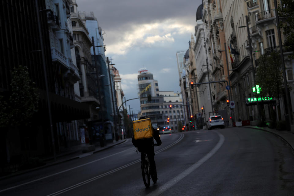 Un repartidor circula en bicicleta por la Gran Vía de Madrid (España) sin viandantes y con apenas vehículos el 16 de marzo. (Foto: Susana Vera / Reuters).