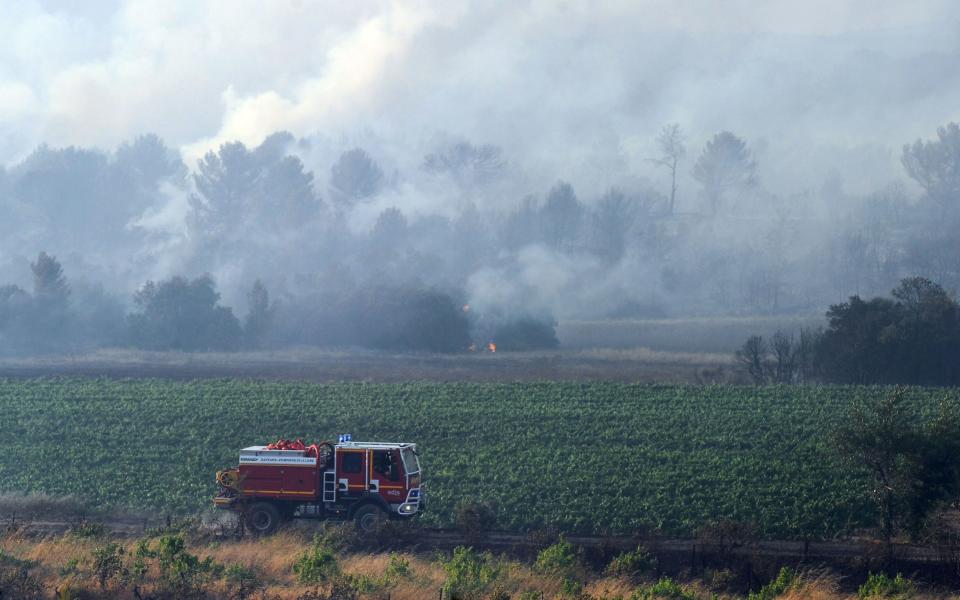 Firefighters try to extinguish a forest fire in Saint Cannat, near Aix en Provence, in the Bouches du Rhone region. More than 800 hectares have burned in the area located in the north-west of Aix-en-Provence - AFP