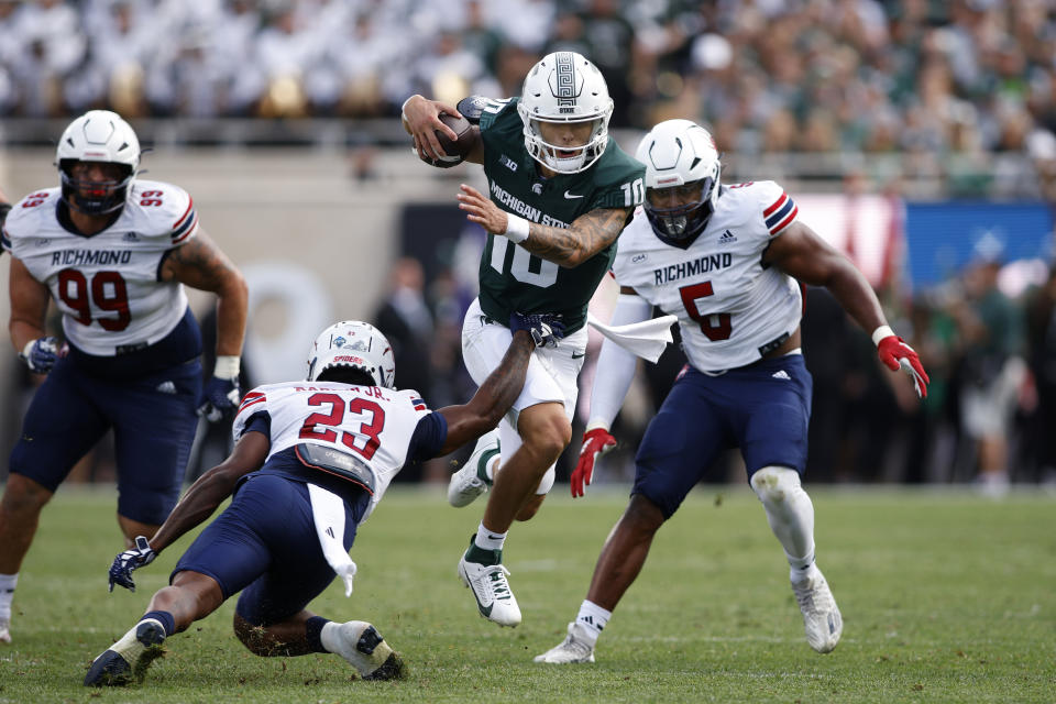 Michigan State quarterback Noah Kim, center, runs against Richmond's Angelo Rankin Jr. (23), Marlem Louis, right, and Aidan Murray, left, during the first half of an NCAA college football game, Saturday, Sept. 9, 2023, in East Lansing, Mich. (AP Photo/Al Goldis)