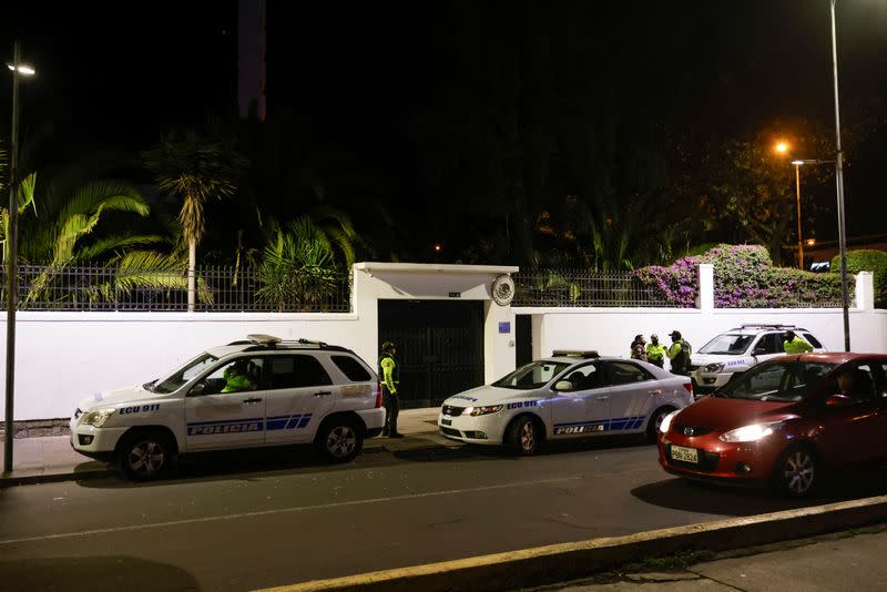 Police and military officials walk outside the Mexican embassy from where they forcibly removed the former Ecuador Vice President Jorge Glas in Quito