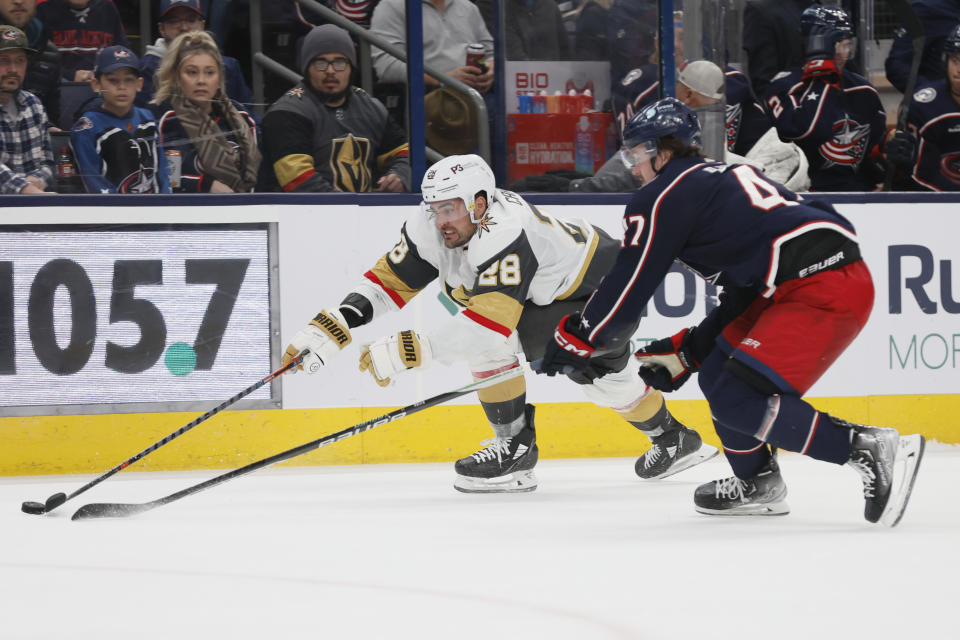 Vegas Golden Knights' William Carrier, left, and Columbus Blue Jackets' Marcus Bjork chase a loose puck during the third period of an NHL hockey game on Monday, Nov. 28, 2022, in Columbus, Ohio. (AP Photo/Jay LaPrete)