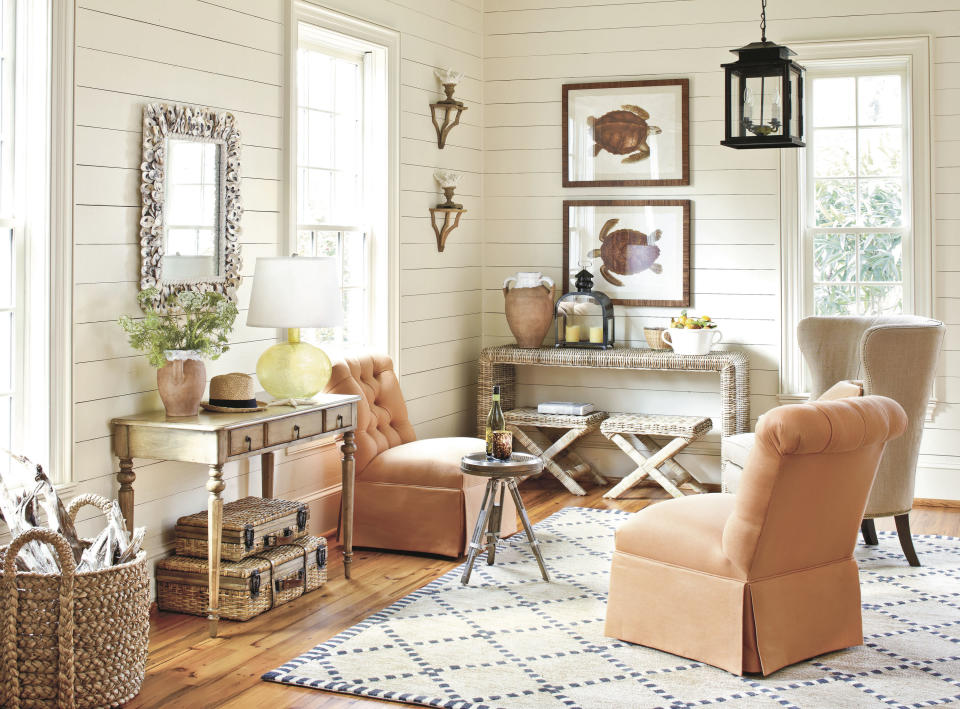 In this image released by Ballard Designs, tufted chairs in a tangerine linen fabric is shown in a living room designed by Ballard Designs. Bold, dramatic and invigorating, Tangerine Tango is dancing its way into home decor trends in 2012 with a punch of reddish-orange panache. The hue is a vivacious alternative to last year’s cheery honeysuckle, and design experts say it’s easy to incorporate into any home. (AP Photo/Ballard Designs)