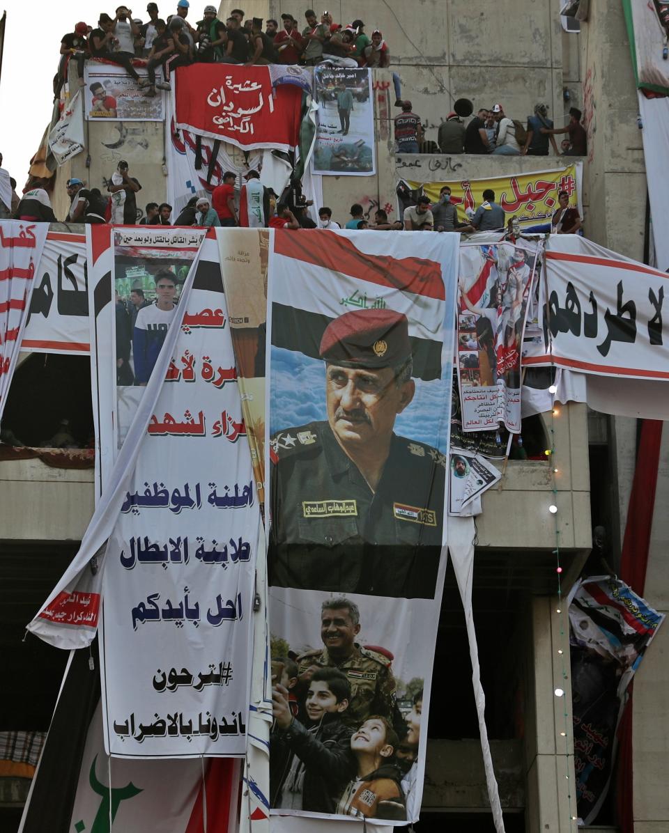 Posters of protesters who have died in anti-government demonstrations and posters of Lt. Gen. Abdul-Wahab al-Saadi, center the former commander of the country's elite counterterrorism forces whose dismissal sparked protests about a month ago, hang on a building near Tahrir Square, in Baghdad, Iraq, Sunday, Nov. 3, 2019. (AP Photo/Khalid Mohammed)
