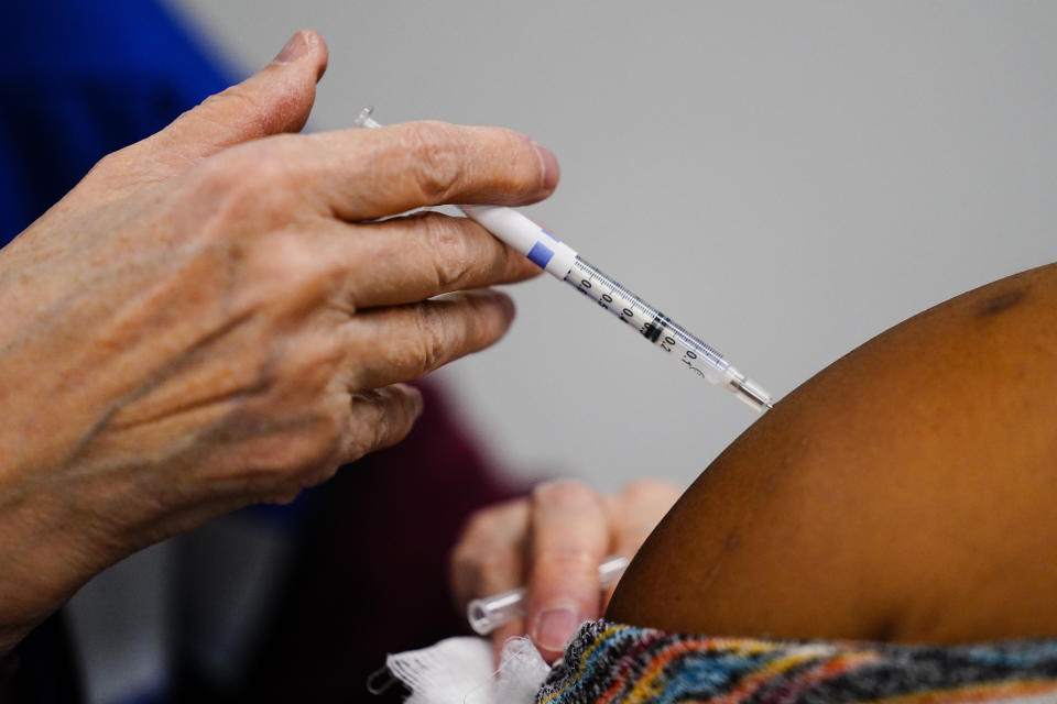 FILE - A health worker administers a dose of a COVID-19 vaccine during a vaccination clinic at the Keystone First Wellness Center in Chester, Pa., Wednesday, Dec. 15, 2021. On Friday, Dec. 17, 2021, a federal appeals court panel allowed President Joe Biden's COVID-19 vaccine mandate for larger private employers to move ahead. (AP Photo/Matt Rourke, File)