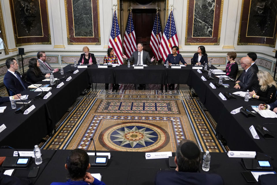 Doug Emhoff and Jewish leaders sit at desks during a roundtable discussion.