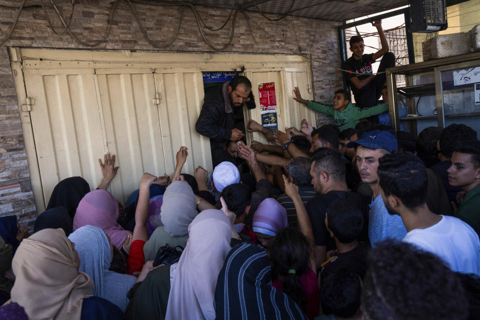 A crowd of Palestinians presses up against a bakery to buy bread in Khan Younis, Gaza Strip, Sunday, Oct, 15, 2023. (AP Photo/Fatima Shbair)