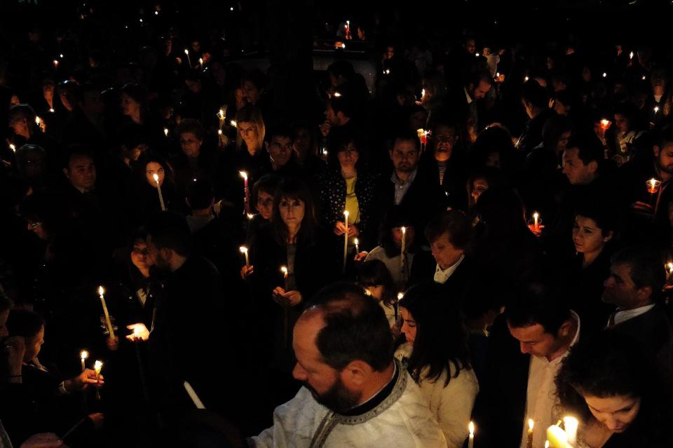 Worshippers hold their candles outside the Prophet Elias church in Chrisopoulis near city of northern city of Kavala, Greece, Saturday, April 19, 2014. More than 250 million Orthodox Christians worldwide will celebrate Easter this year on Sunday, April 20. (AP Photo/Petros Karadjias)