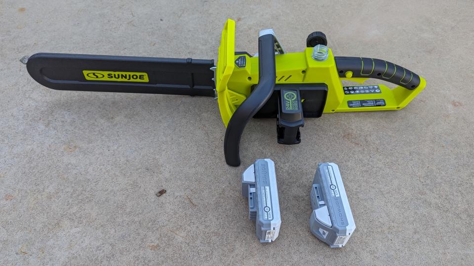 The two 24-volt batteries fit on the side of the chainsaw. This image shows the chainsaw, batteries and the dual port charger.