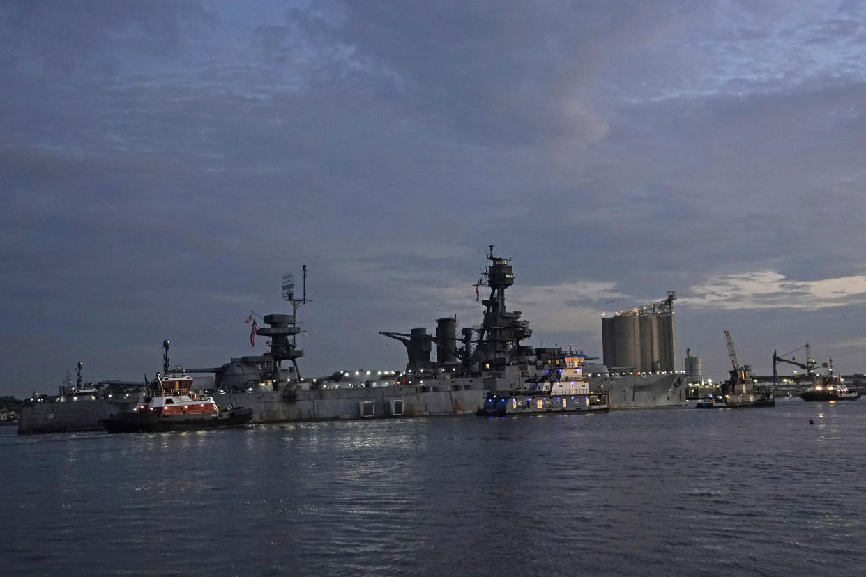 The USS Texas is moved by tugboats Wednesday, Aug. 31, 2022, in La Porte, Texas. The vessel, which was commissioned in 1914 and served in both World War I and World War II, is being towed down the Houston Ship Channel to a dry dock in Galveston where it will undergo an extensive $35 million repair. (AP Photo/David J. Phillip)