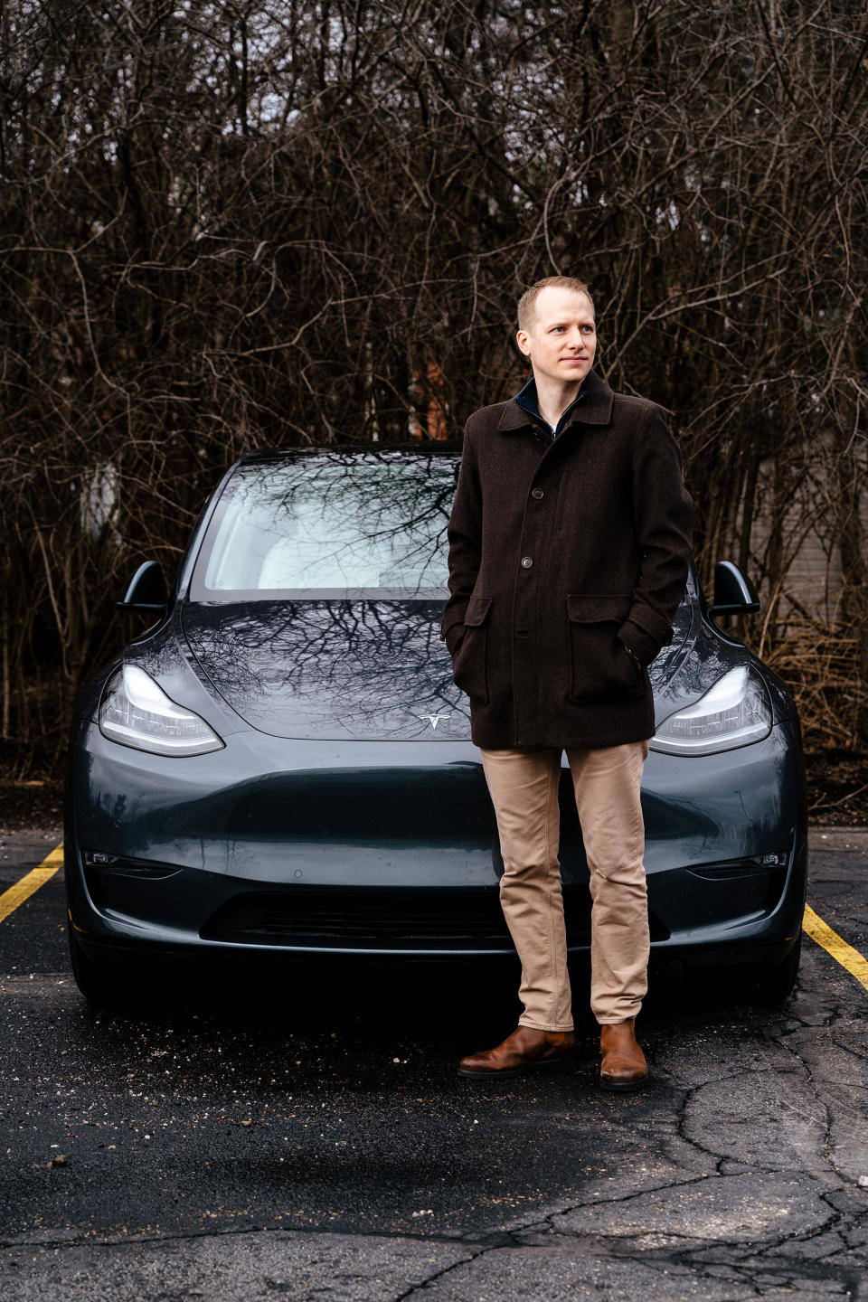 Matt Smith, 35, poses with his Tesla Model Y. (Nick Hagen for NBC News)