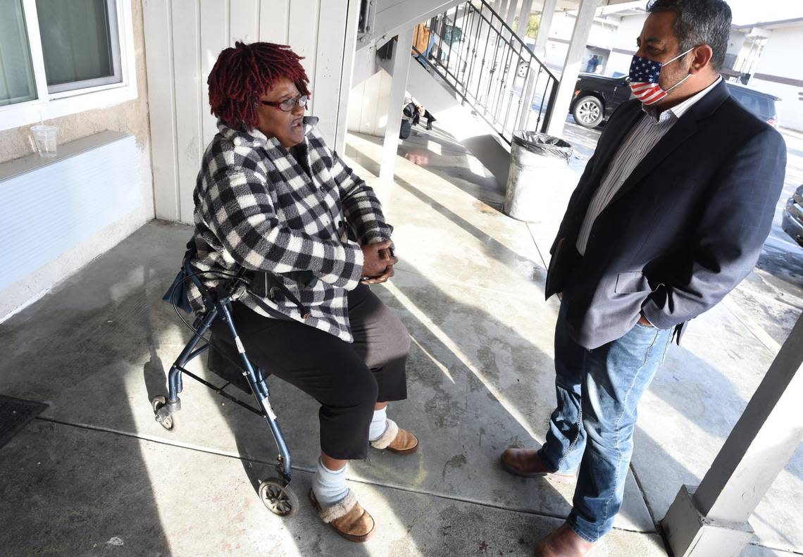 Fresno City Councilmember Miguel Arias talks with shelter resident Debra Wallace, Jan. 28. 2022. Formerly homeless for over seven years, she was living in various cars, until finding this shelter run at the site of the former Travel Inn and Suites.