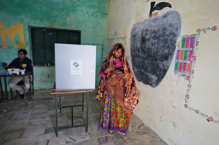 A woman holds her baby as she leaves after casting her vote at a polling station at Sirohi district in Rajasthan, India April 29, 2019. REUTERS/Amit Dave