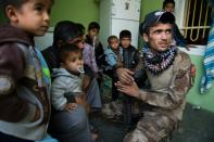 A soldier from the Iraqi Special Forces' 2nd division reassures members of a family sheltered inside a building held by troops during fighting against Islamic State group jihadists in the Arbagiah neighbourhood of Mosul on November 12, 2016