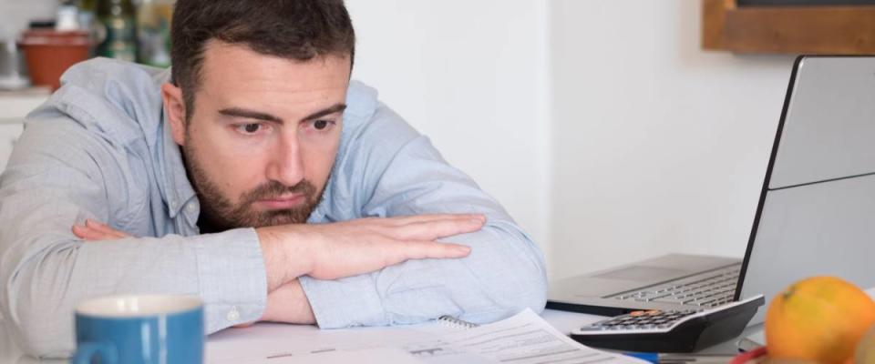 Frustrated man calculating bills and tax  expenses