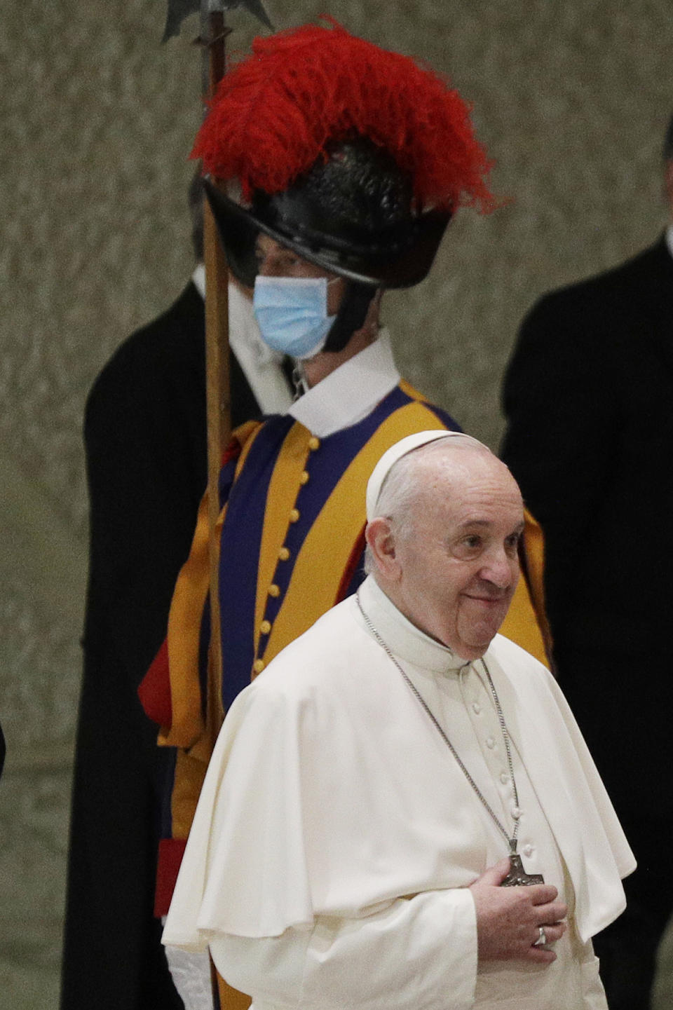 Pope Francis passes by a Swiss guard wearing a face mask to curb the spread of COVID-19 as he arrives in the Paul VI hall on the occasion of the weekly general audience at the Vatican, Wednesday, Oct. 21, 2020. (AP Photo/Gregorio Borgia)