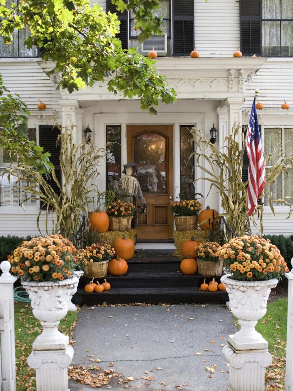 <p>Don't confine pumpkins to the ground: If your porch has a stable overhang, like the one pictured here, use a ladder to elevate your display by placing a few mini pumpkins overhead. </p>