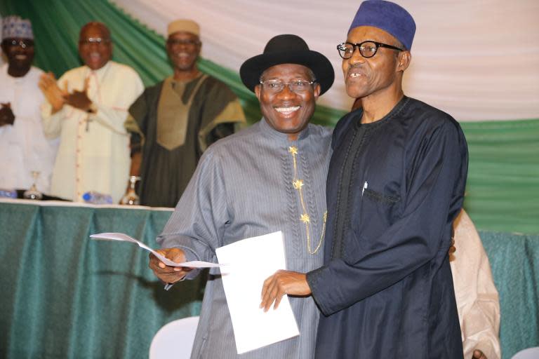 Nigerian President Goodluck Jonathan (left) and APC main opposition party's presidential candidate Mohammadu Buhari smile after signing the renewal of the pledges for peaceful elections in Abuja on March 26, 2015