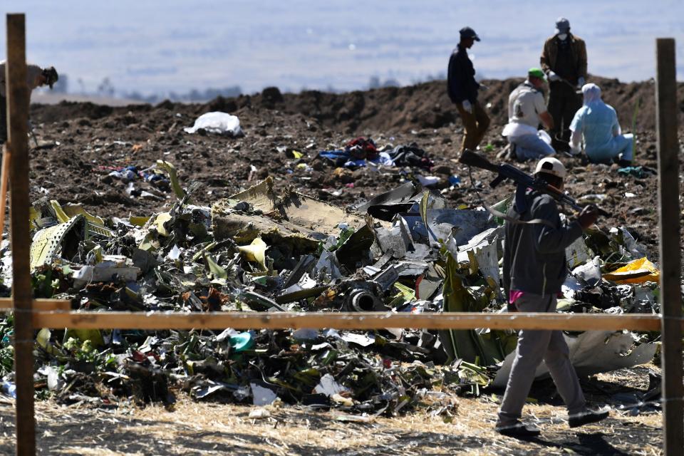 An Oromo man hired to assist forensic investigators walks by a pile of twisted airplane debris at the crash site of an Ethiopian airways operated Boeing 737 MAX aircraft on March 16, 2019 at Hama Quntushele village near Bishoftu in Oromia region. - A French investigation into the March 10 Nairobi-bound Ethiopian Airlines Boeing 737 MAX crash that killed 157 passengers and crew opened on March 15 as US aerospace giant Boeing stopped delivering the top-selling aircraft. (Photo by TONY KARUMBA / AFP)        (Photo credit should read TONY KARUMBA/AFP/Getty Images)