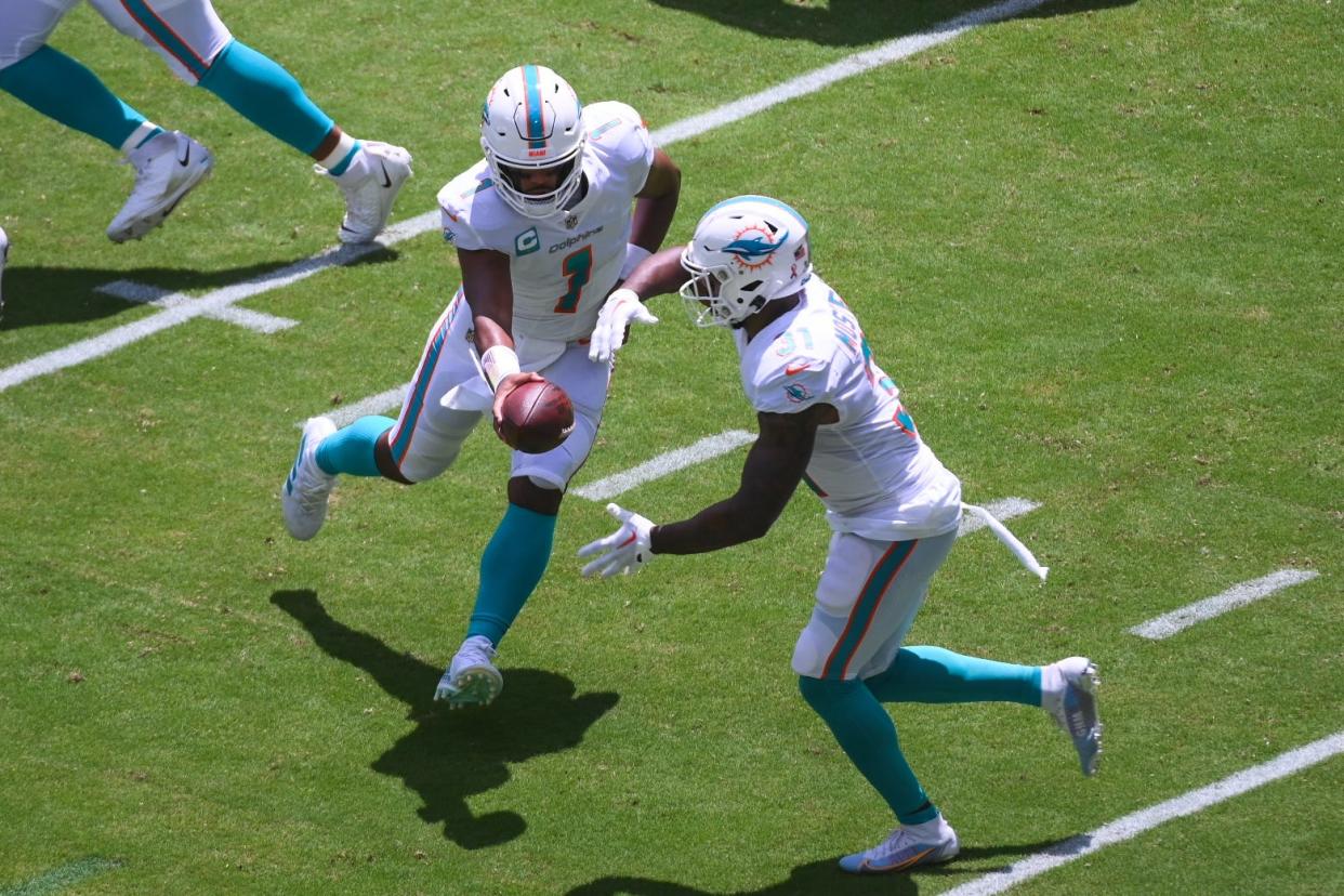 Miami Dolphins quarterback Tua Tagovailoa hands the ball off to  running back Raheem Mostert. Tua is 4-0 against Bill Belichick and the Patriots. Recent history proves Miami is now an AFC playoff contender.